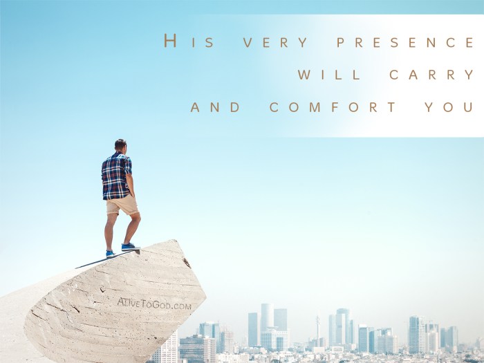 Young man standing on a cliff and looking at the city